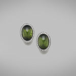 A pair of BUNDA 'Corvus' tourmaline earrings in 18ct white gold, featuring a pair of cabochon cut green tourmalines, bezel set and surrounded with threadset round brilliant cut diamonds, fitted with a post and keyhole clip fitting.  Weight of tourmalines: 2 = 14.50ct.  Characteristics of diamonds: 68 = 0.34ct, F colour, VS clarity.
