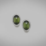 A pair of BUNDA 'Corvus' tourmaline earrings in 18ct white gold, featuring a pair of cabochon cut green tourmalines, bezel set and surrounded with threadset round brilliant cut diamonds, fitted with a post and keyhole clip fitting.  Weight of tourmalines: 2 = 14.50ct.  Characteristics of diamonds: 68 = 0.34ct, F colour, VS clarity.