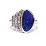 BUNDA 'Devo' opal and diamond ring in 18ct white gold, featuring an Australian Boulder Opal, and three rows of thread set round brilliant cut diamonds.  Characteristics of Opal: 1 = 2.76ct, displaying a range of green and blue colours. Origin: Queensland, Australia.  Characteristics of diamonds: 21 = 0.18ct, F colour, VS clarity.  Total weight of Ring: 9.15 grams