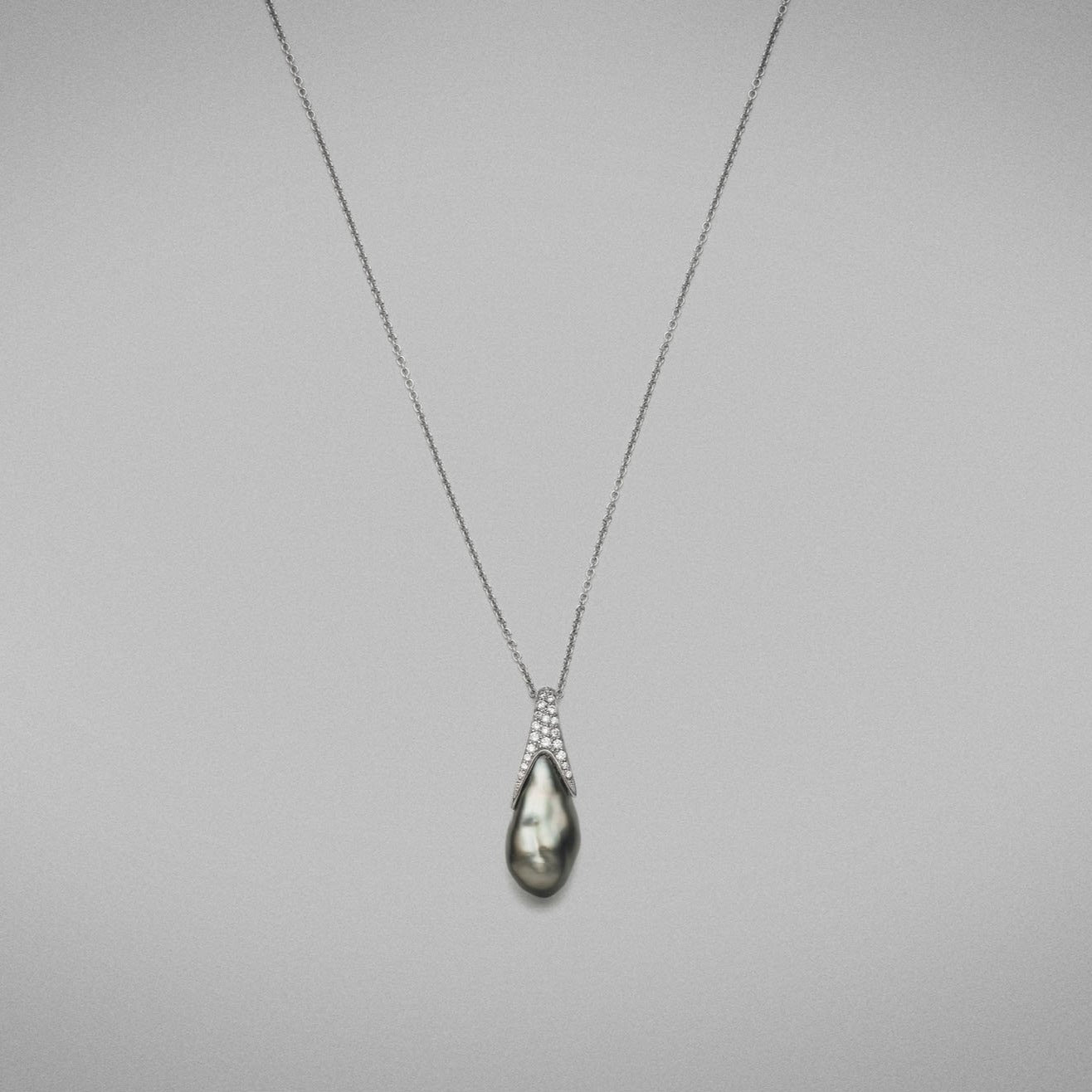 'Caelum' Cultured Tahitian Keshi pearl and Diamond Pendant in 18 carat white gold, featuring a baroque shaped Keshi pearl, set with a diamond thread-set cap that follows the curve of the pearl and is fitted with an 18 carat white gold trace chain.  Characteristics of Diamonds: 0.15cts. F Colour, VS Clarity  Total weight of pendant: 5.82 grams