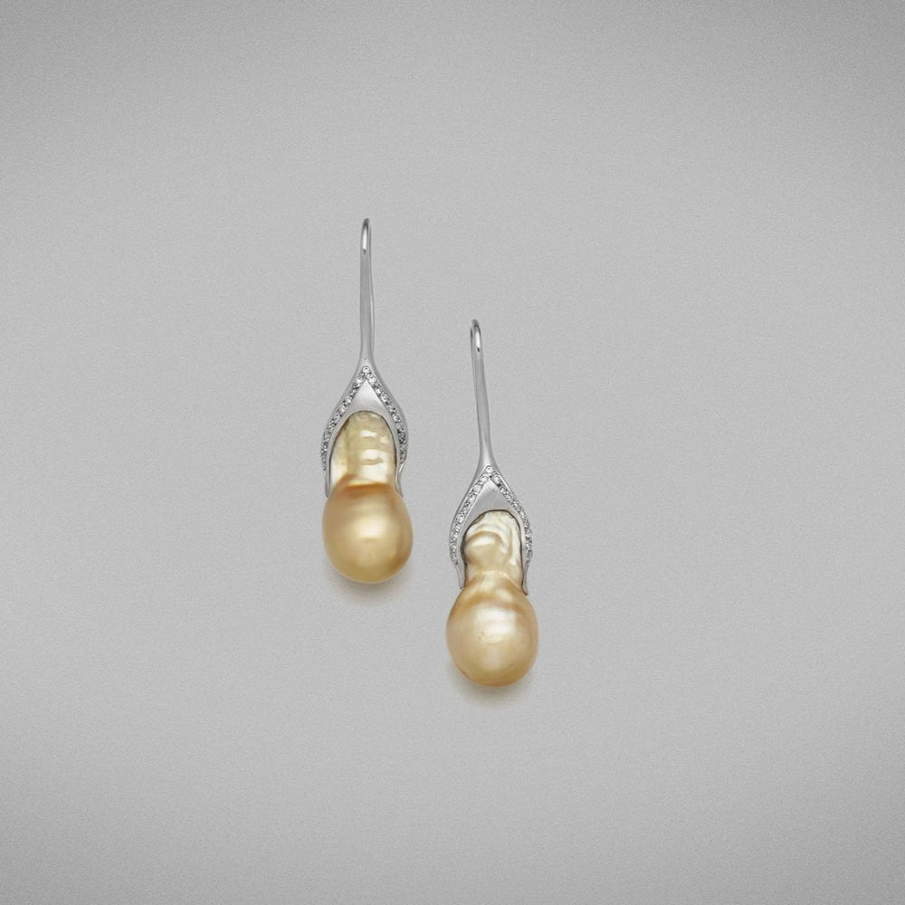 A pair of BUNDA 'Caelum' Golden Cultured South Sea pearl earrings, set with baroque shaped pearls fitted on to threadset diamond hooks in 18 carat white gold.  Dimensions of pearls: 10.00 - 11.00mm  Characteristics of diamonds: 38= 0.16ct, F colour, VS clarity.