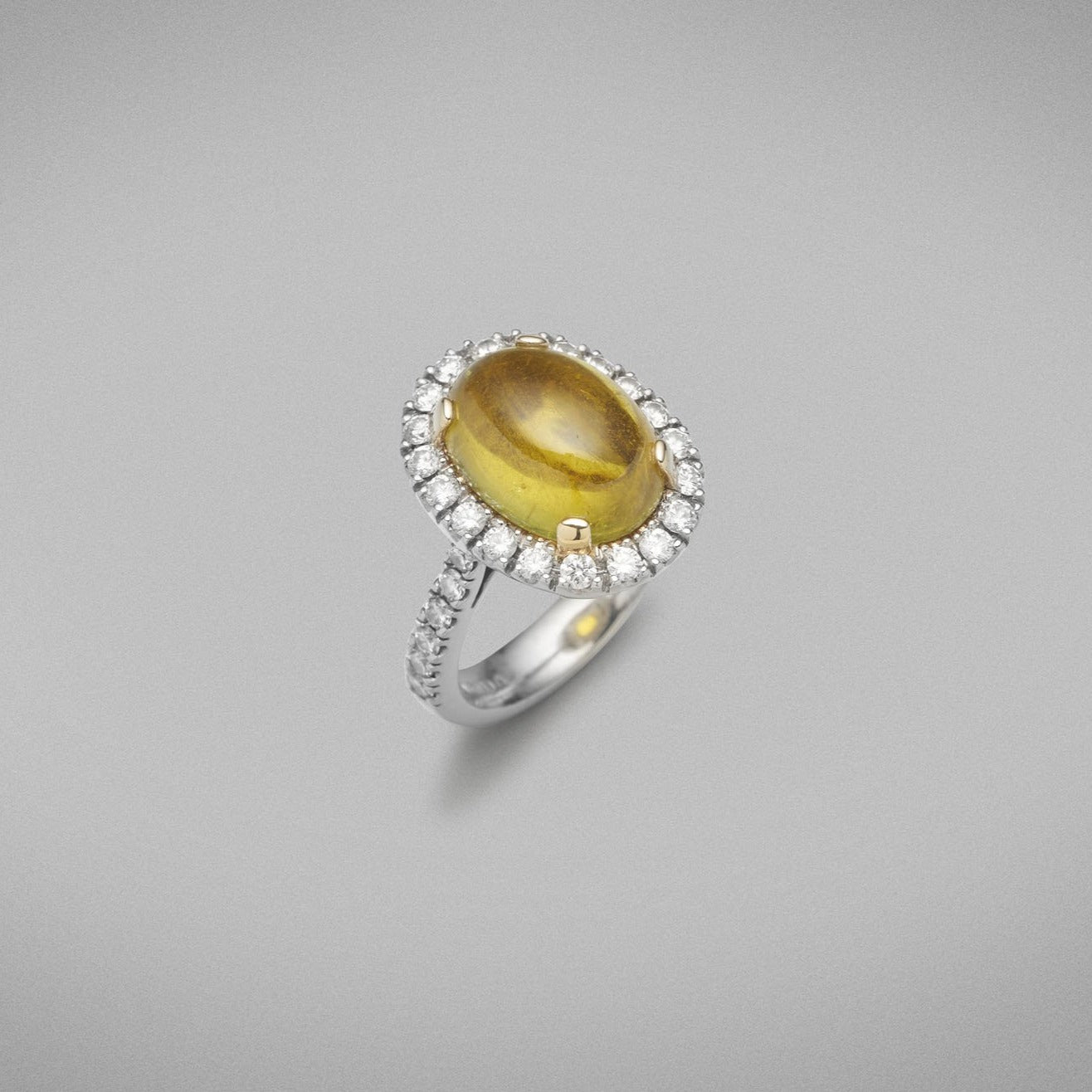 A BUNDA 'Valentin' Tourmaline and diamond ring in platinum and 18ct yellow gold, featuring a cabochon cut Tourmaline, surrounded with castle set round brilliant cut diamonds to the head and shoulders.  Weight of Tourmaline: 1 = 6.64ct  Characteristics of additional diamonds: 32 = 1.01ct, F colour, VS clarity.  Total weight of Ring: 12.28 grams.