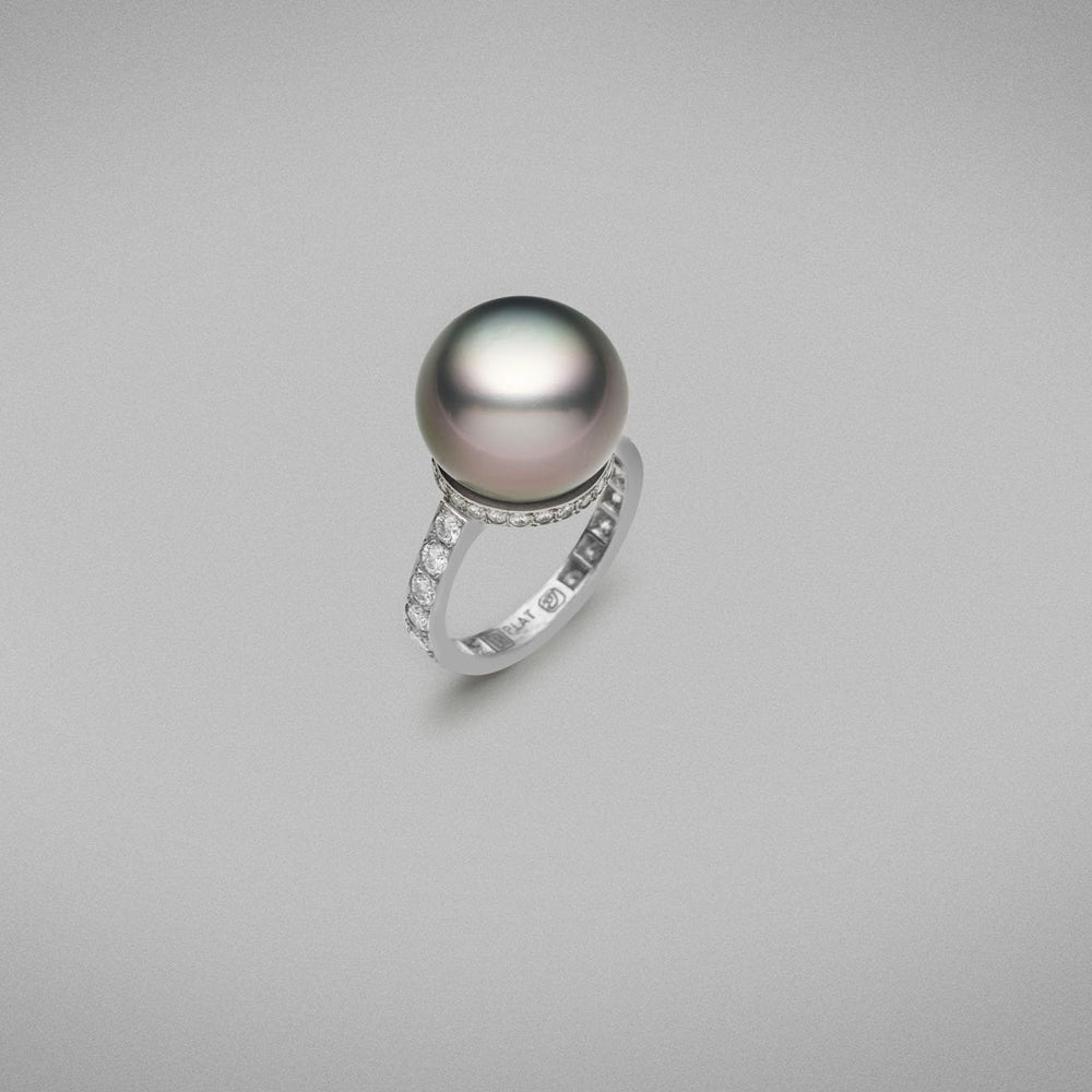 A BUNDA 'Tanara' Cultured Tahitian pearl and diamond ring in platinum, featuring a button shaped pearl, set on a base of threadset round brilliant cut diamonds, fitted to a band, also with threadset round brilliant cut diamonds.  The tahitian pearl is grey/green with pink tones in colour, measures approximately 14.80mm, has a clean skin and an excellent lustre.  Characteristics of diamonds: 40 = 1.15ct, F colour, VS clarity.  Total weight: 8.56g