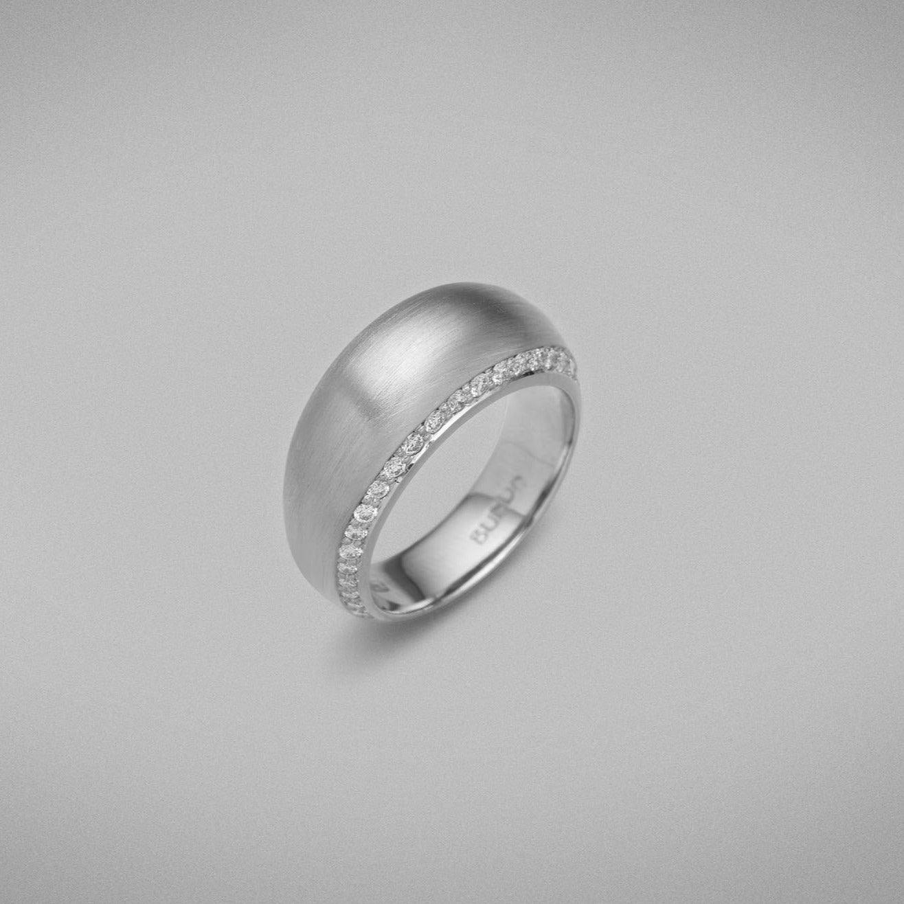 A BUNDA 'Bundova' Diamond Ring in Platinum. The ring has a high dome lined with thread-set round brilliant diamonds on both sides. Ring is stamped 'BUNDA'.  Characteristics of Round Brilliant Cut Diamonds: 50 = 0.49ct, F Colour, VS Clarity  Total weight of Ring: 15.01 grams