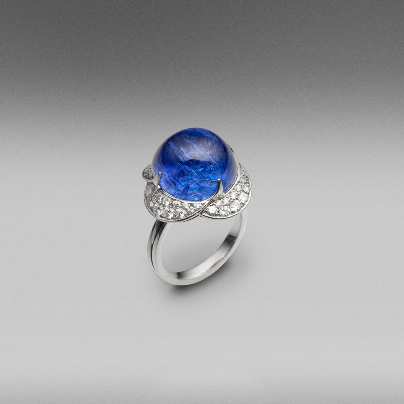 A BUNDA 'Couture' tanzanite and diamond ring in platinum, featuring a cabochon cut tanzanite, surrounded with round brilliant cut diamonds, pave set into the surrounding petals.  Characteristics of Tanzanite: 1 = 19.18ct.  Characteristics of diamonds: 48 = 1.00ct, F colour, VS clarity.  Total weight of ring: 12.70 grams.