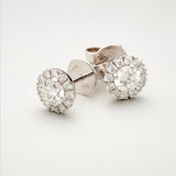 A pair of BUNDA 'Valentin' diamond earrings in 18 carat white gold, each featuring a round brilliant diamond, claw set to the center of each earring and surrounded with castle set, round brilliant cut diamonds. Fittings are post and butterfly.  Total diamond weight .90ct 