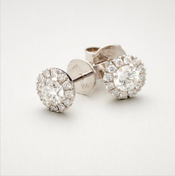 A pair of BUNDA 'Valentin' diamond earrings in 18 carat white gold, each featuring a round brilliant diamond, claw set to the center of each earring and surrounded with castle set, round brilliant cut diamonds. Fittings are post and butterfly.  Total diamond weight .90ct 