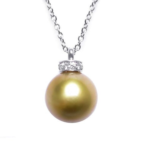 A BUNDA Cultured South Sea pearl and diamond 'Dorado' pendant in 18 carat white gold, featuring a round shaped pearl of clean skin and excellent lustre, gold in colour, fitted with a diamond set cap and an 18 carat white gold Trace chain. Dimensions of pearl: 9.50 - 10.00mm Characteristics of diamonds: 11 = 0.09ct, F colour, VS clarity.